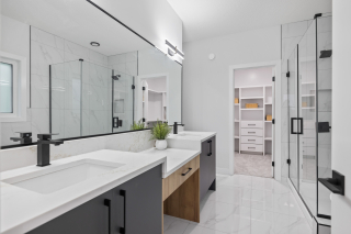 Modern ensuite bathroom with double vanity and glass shower in Edmonton custom home