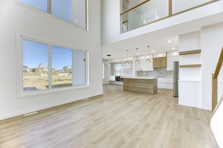 bright and spacious great room int he Aria model by Vita Homes, featuring floor-to-ceiling windows and a modern open-concept layout