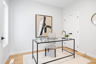 Stylish home office in the Bellagio model by Vita Homes, with minimalist decor and sleek glass desk — available in Edmonton and Beaumont from expert custom home builders