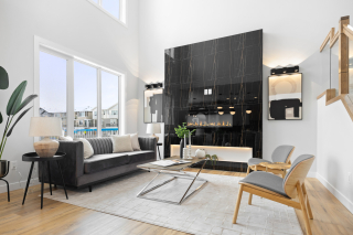 Double-height great room with black marble fireplace and modern interior design in the Bellagio model by Vita Homes — custom home builder in Edmonton and Beaumont