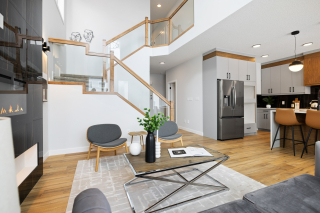 Elegant open-concept layout in the Bellagio model with a floating staircase and feature wall - built by leading new home builders in Edmonton and Beaumont