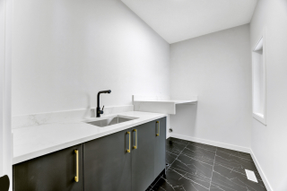 Laundry room in the mirage home, featuring tile floors and sink