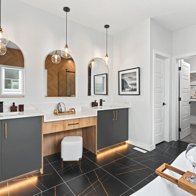 Luxurious master ensuite featuring his and her sinks and a central makeup desk in the Bellagio with Bar design